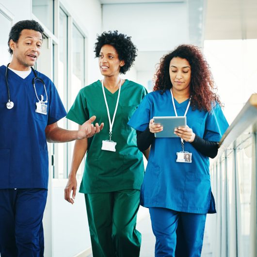 Group of medical professionals discussing along hospital corridor